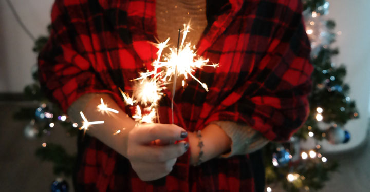 woman in flannel holding sparkler