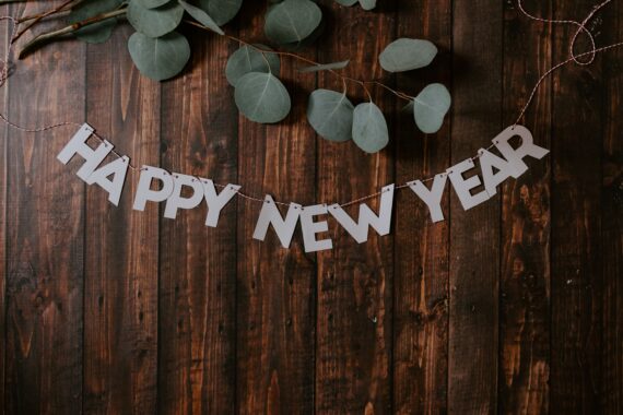 Happy New year banner on table with greens