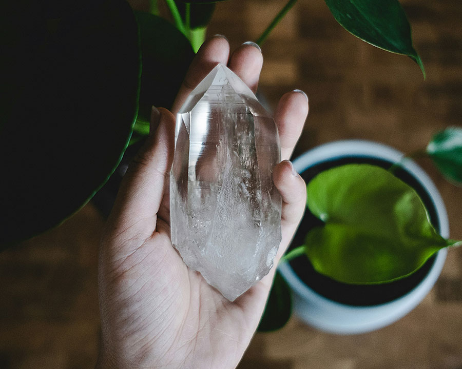 woman holding tower of clear quartz